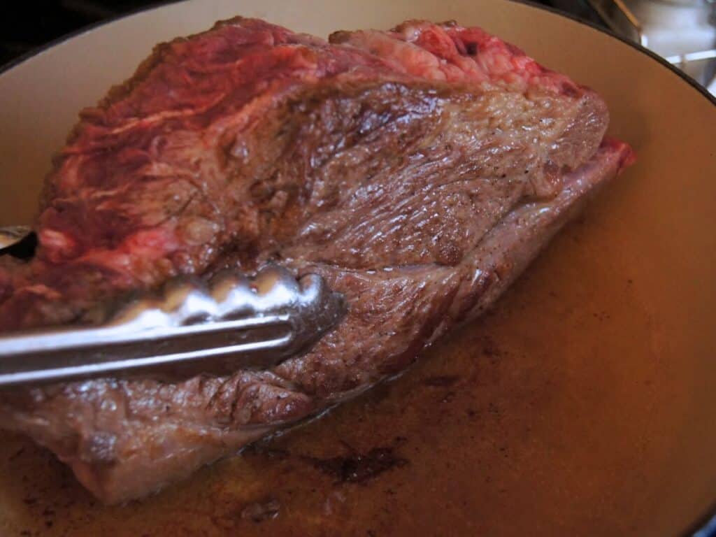 Image shows roast seared in a pan.