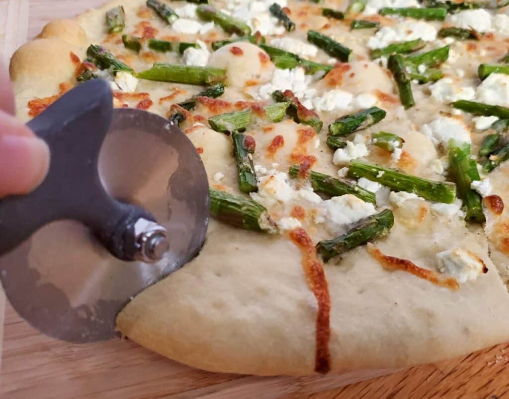 Slicing into an asparagus goat cheese pizza