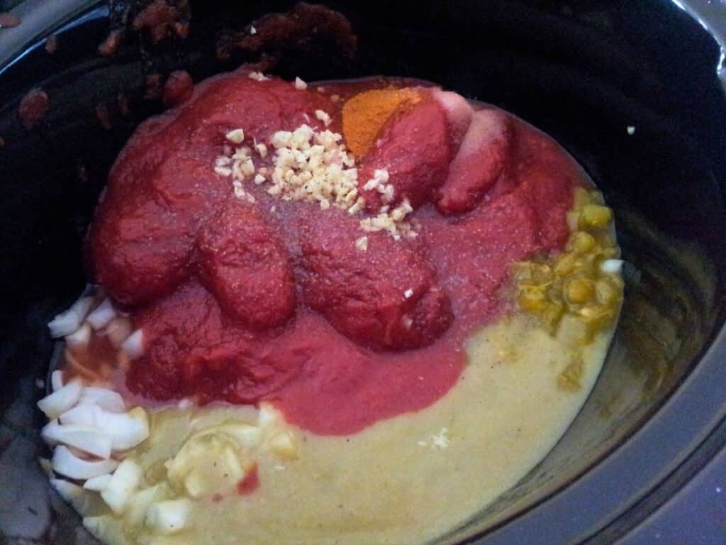 Image shows ingredients of homemade tortilla soup in a pot.