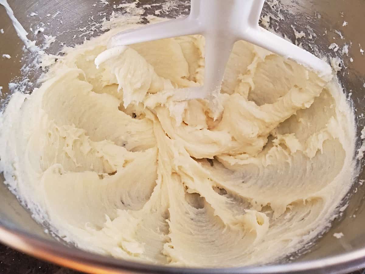 Cream cheese blended well with sugar in a silver bowl.