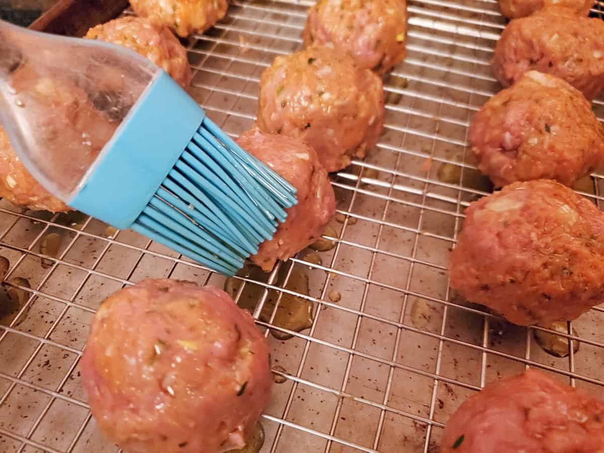 Brush sweet potato meatballs with olive oil using a pastry brush.