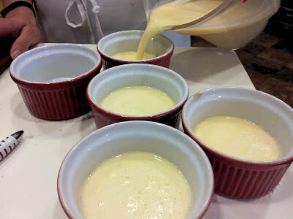 Image shows creme brulee poured into ramekins.
