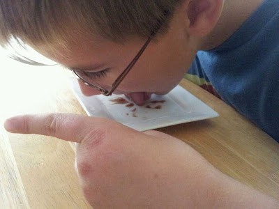 Boy licking a plate clean.
