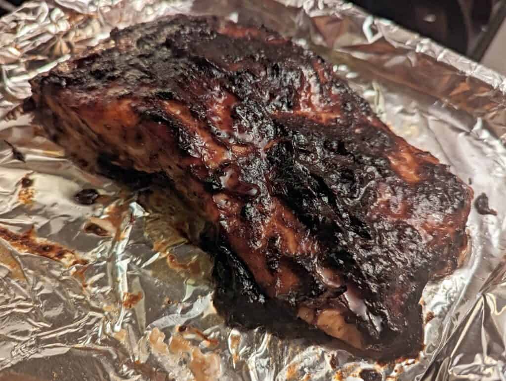 Asian glazed salmon fillet on a foil lined sheet.