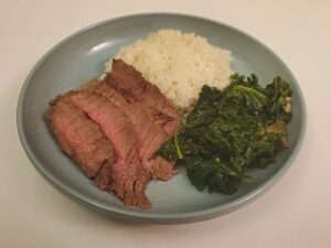 Asian marinated steak dinner on a blue plate.