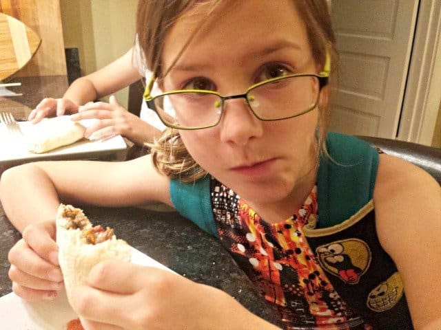 Loving her dinner so much she didn't even take off her backpack