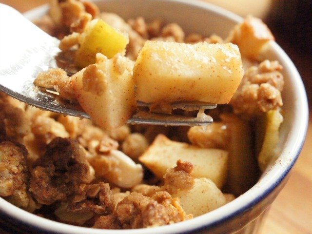 Fresh apple granola crisp closeup with a fork holding a bite.