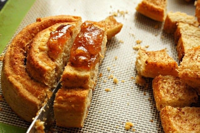 Slicing cinnamon rolls into chunks for bread pudding