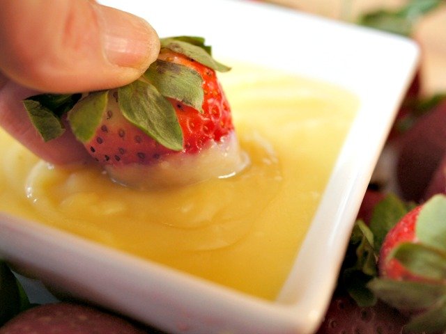 Dipping strawberries in pineapple curd