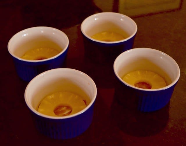 Add pineapple and cherries to mini pineapple upside down cake cups