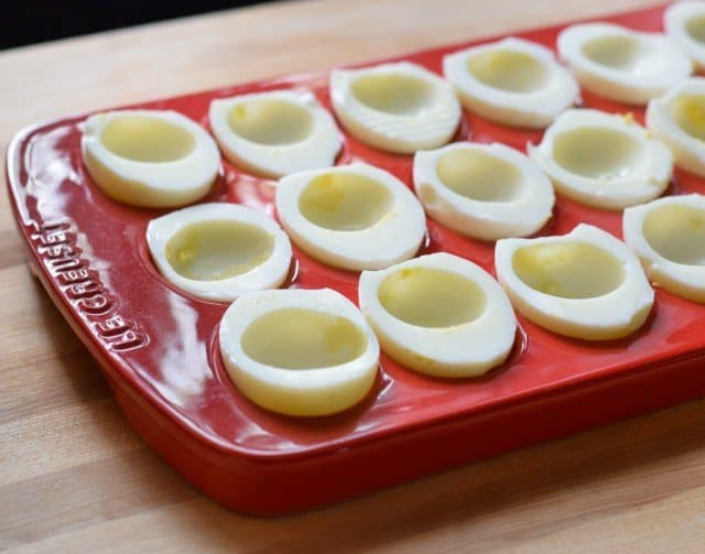 Add egg white halves to Le Creuset deviled egg platter