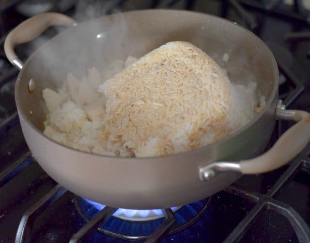 Add cold rice to cooked chicken and onion