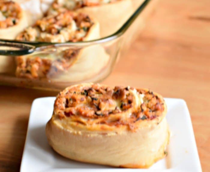 Image shows a Pizza roll on a white plate in front of a pyrex with the rest of the batch in it.