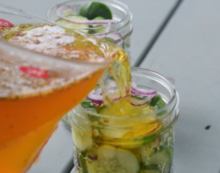 Pour brine into pickle jars