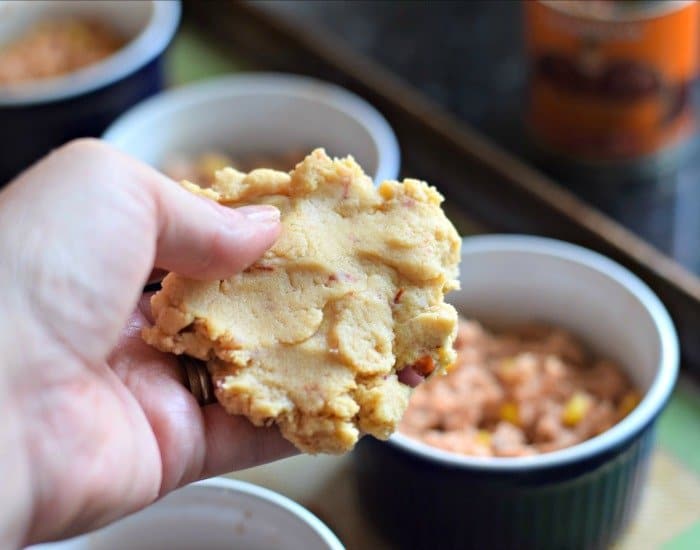 Add masa topping to tamale filled ramekins