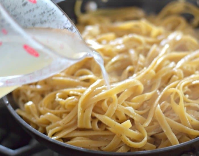 Add pasta water to pasta to create sauce for cacio e pepe