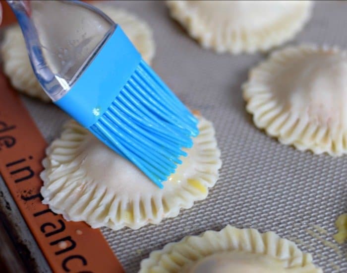 Brush tops of weeknight chicken empanadas with egg wash