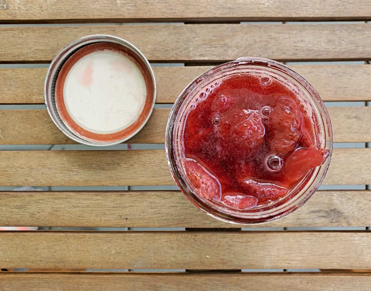 Looking overhead at a jar of strawberry syrup.