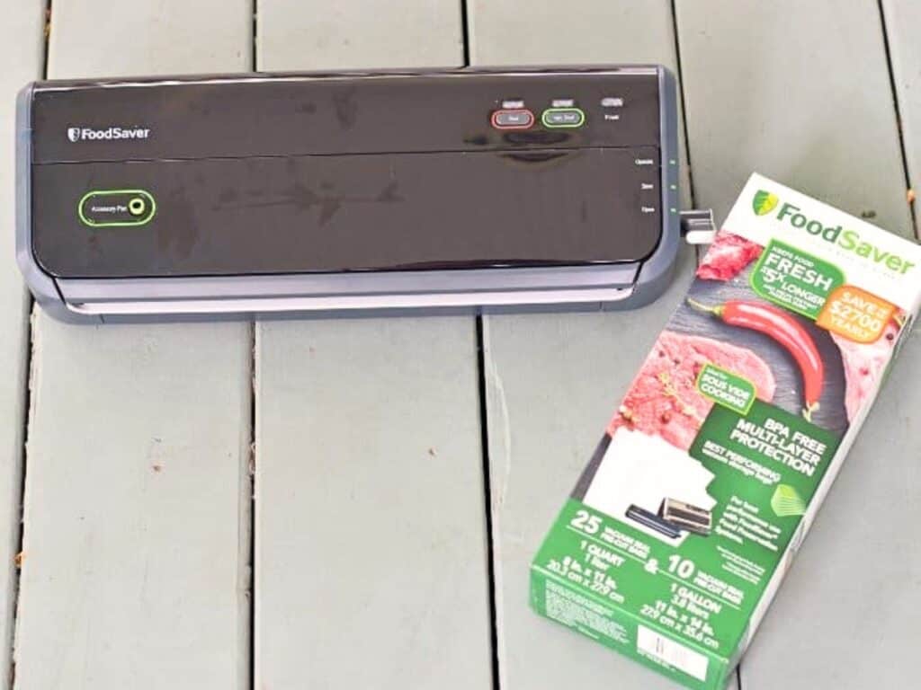 A FoodSaver vacuum sealer sits on a wooden surface next to a box of FoodSaver BPA-free vacuum seal bags—ideal for preparing sous vide miso glazed salmon with perfectly sealed in freshness and flavor.
