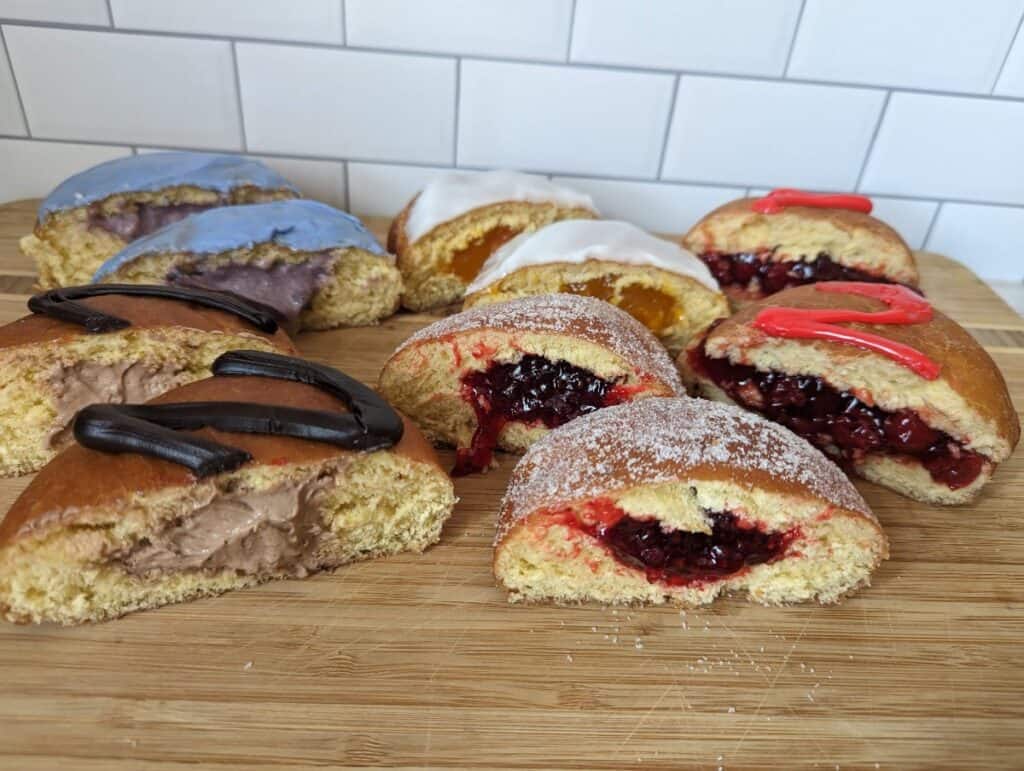Paczki cut in half on a board from Chicago Pastry.