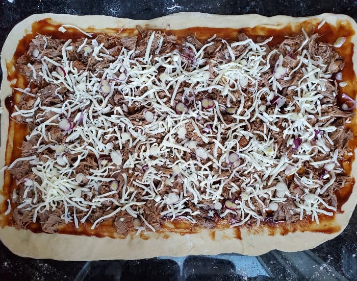Sprinkle red onion over pizza