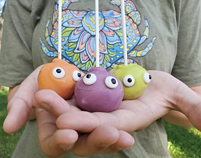 Holding three monster cake pops