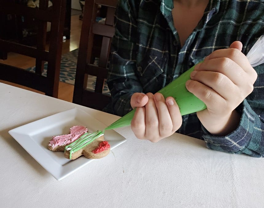 Holding icing bag to decorate gingerbread cookie pirate
