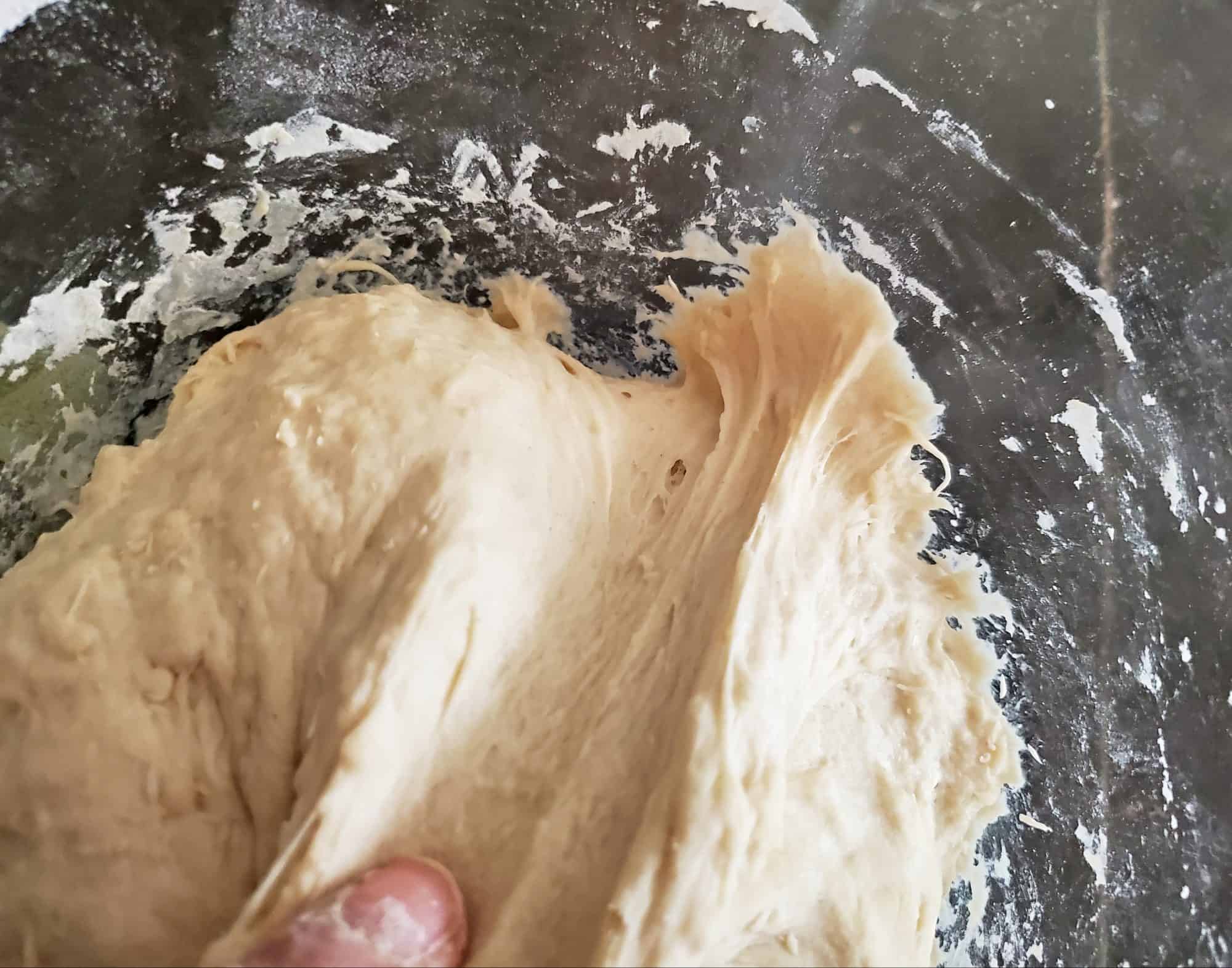 Sticky sourdough bread dough in a bowl.