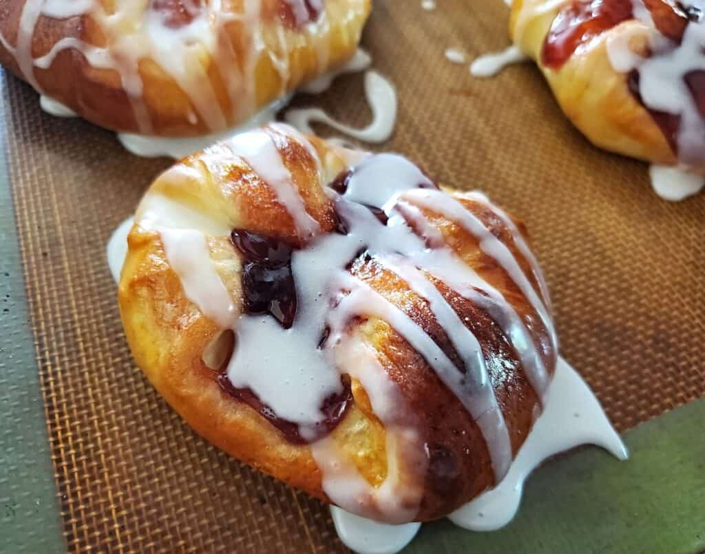 Silpat with three crescent roll danishes.