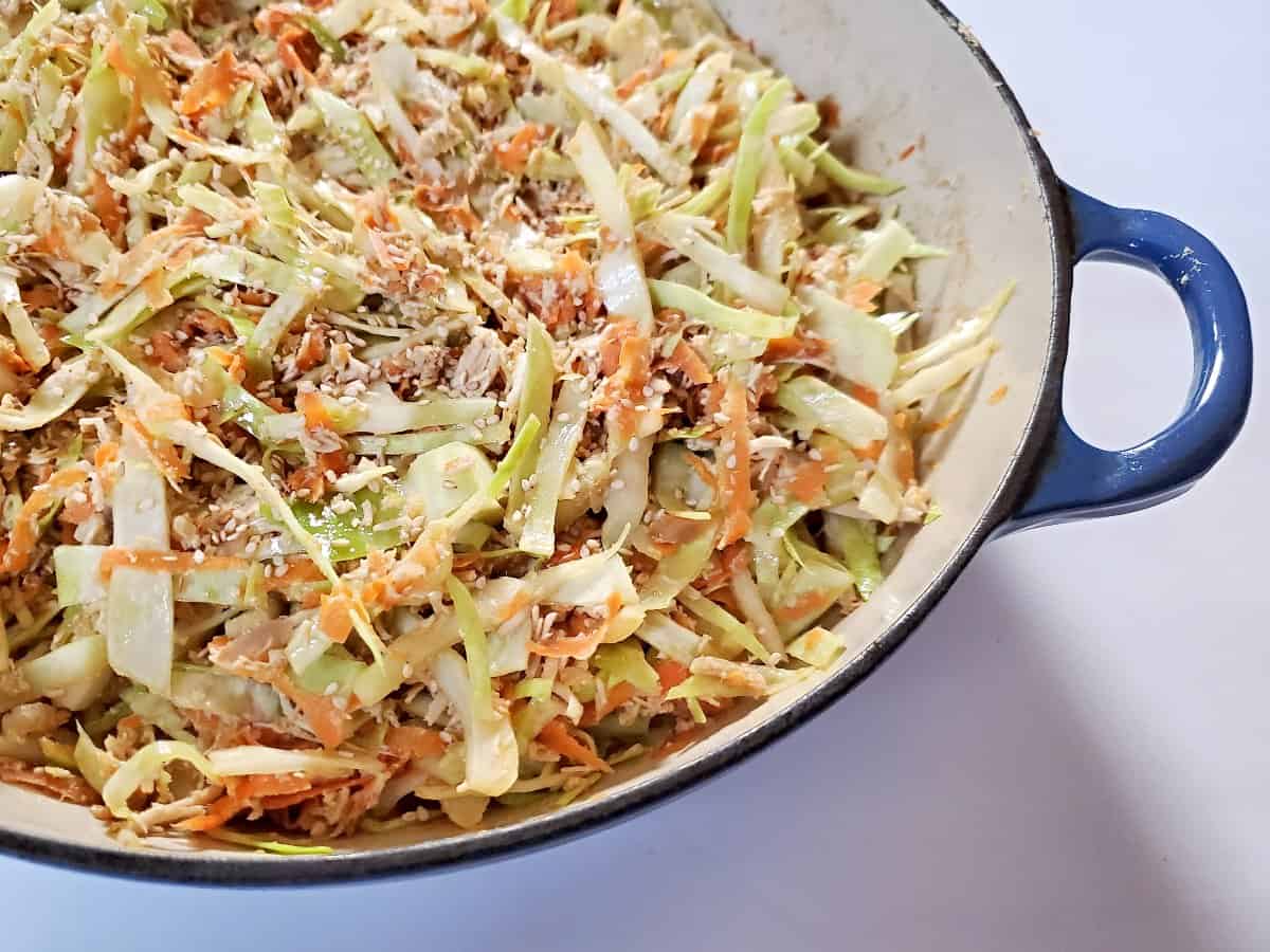 Close view of deconstructed egg roll in an enameled cast iron pan.