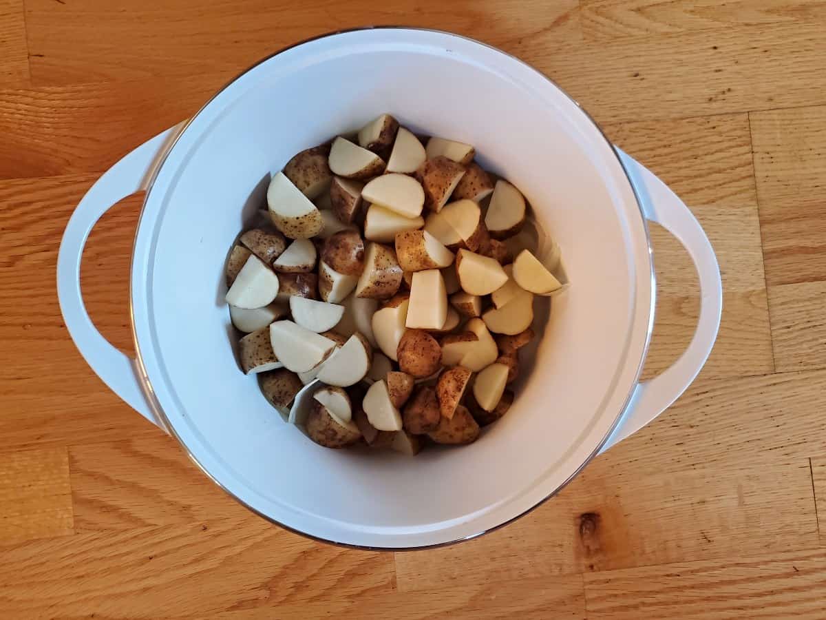 Sliced potatoes in a dutch oven.