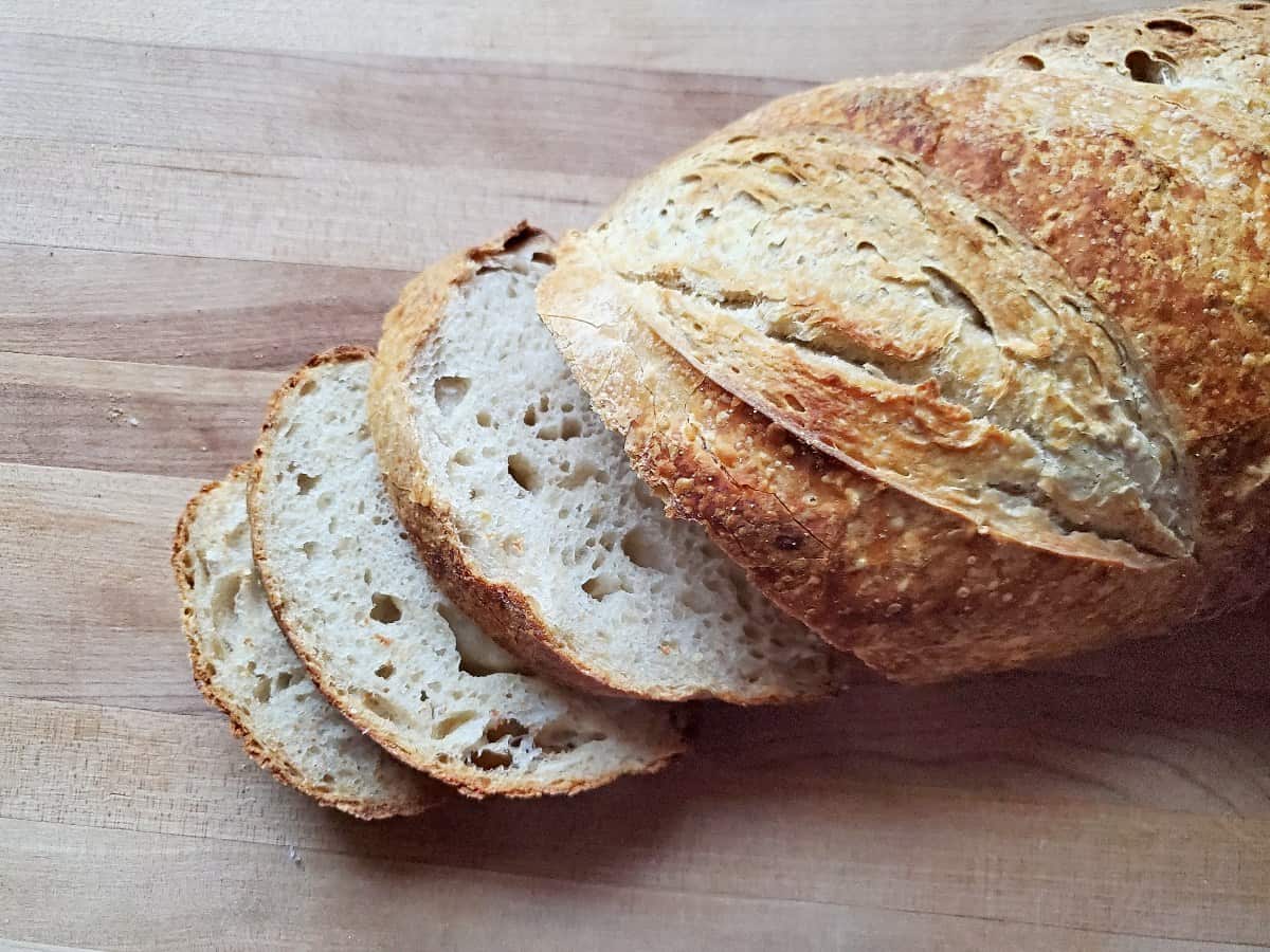 Overhead shot of sourdough life with three slices cut off.
