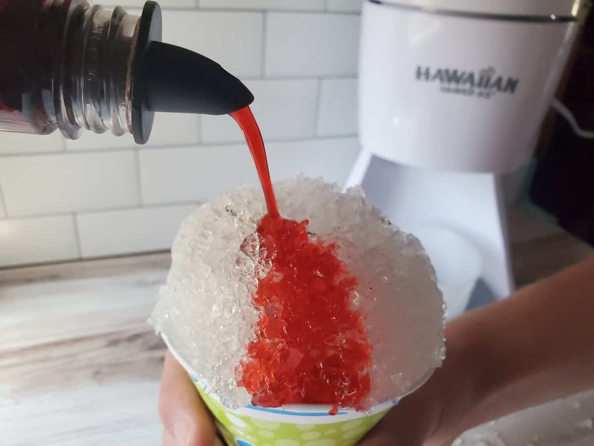 Adding syrup to a snow cone.