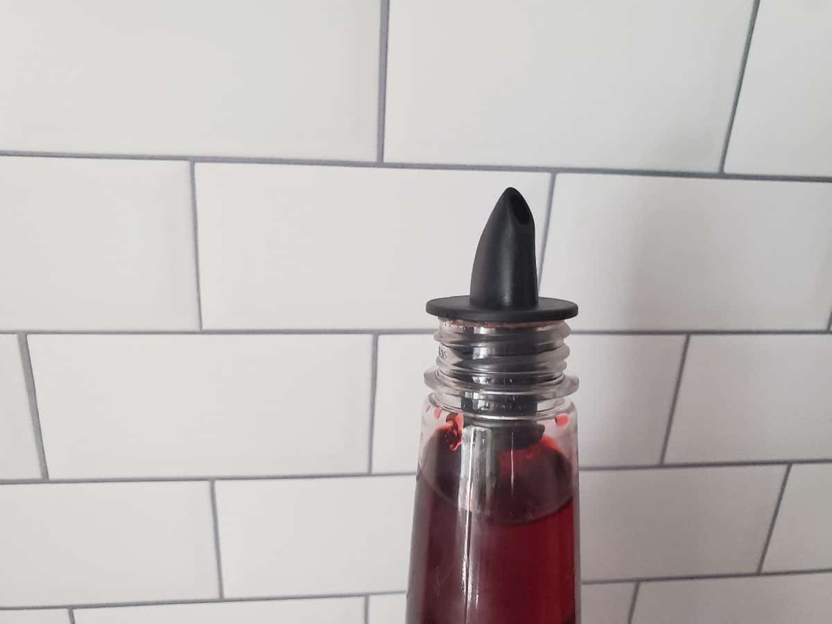 Close up of a spout pourer on a flavored syrup bottle.