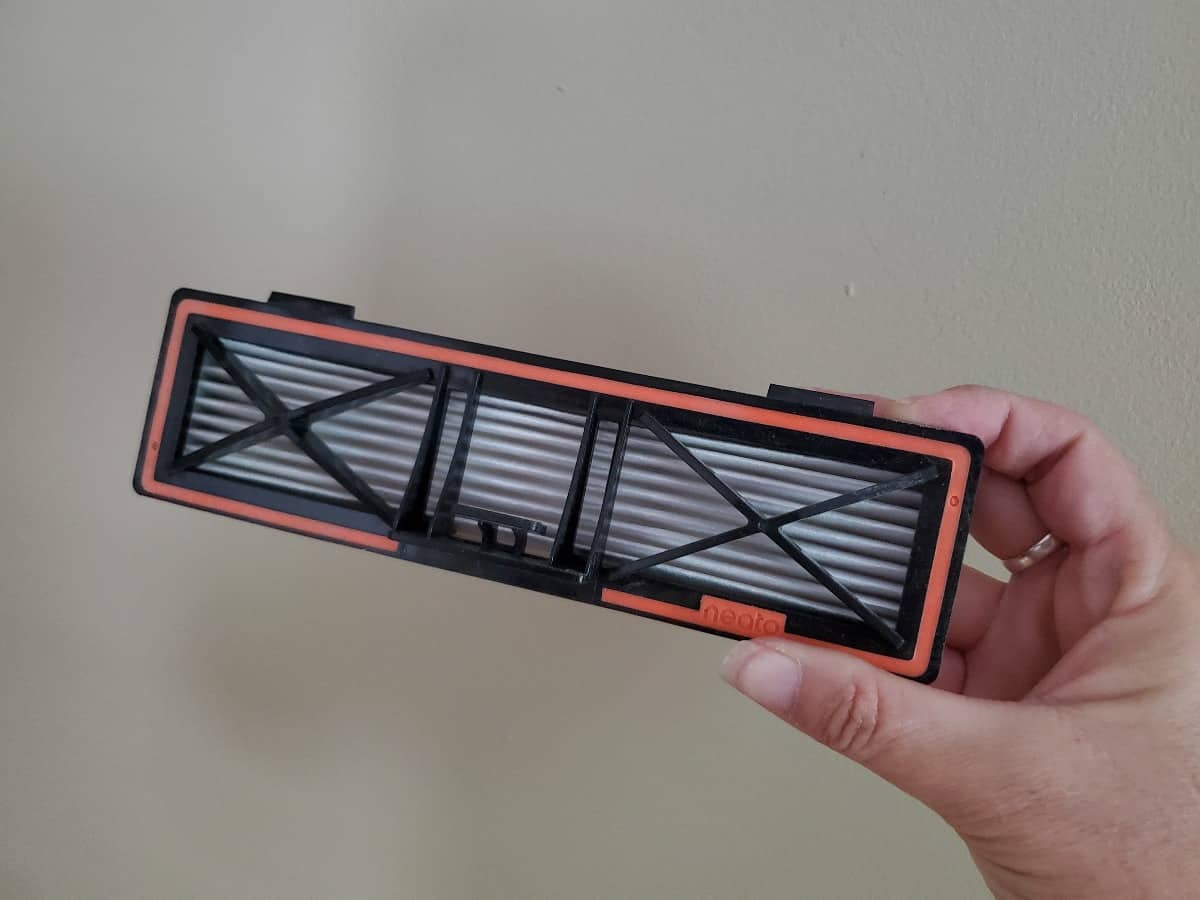 Hand holding up the Pleated side of the Neato D10 HEPA filter.