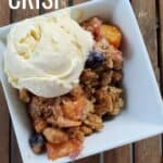 Overhead of crisp with ice cream and text summer fruit crisp.