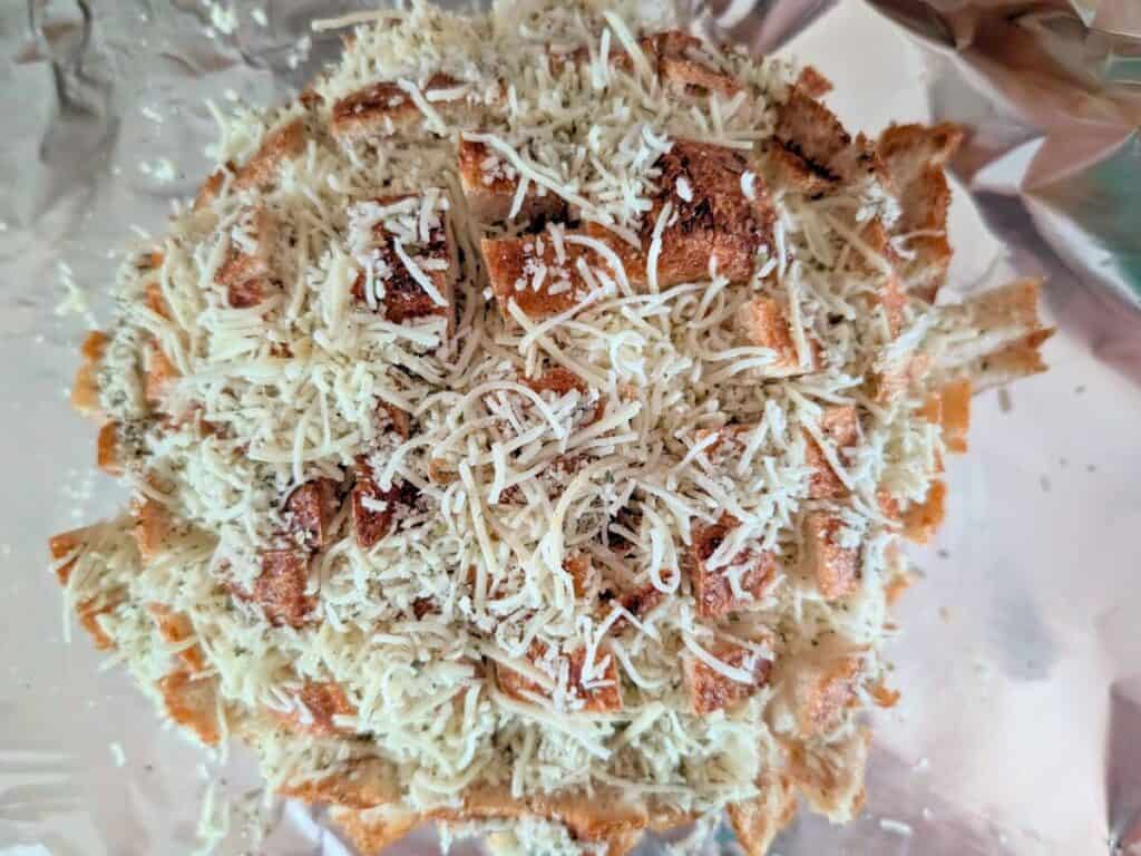 Image shows freshly baked sourdough loaf being filled with cheese.