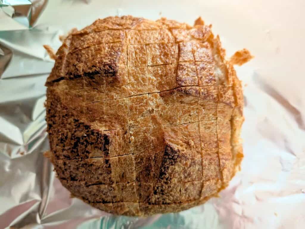 Image shows freshly baked sourdough loaf with golden crust.