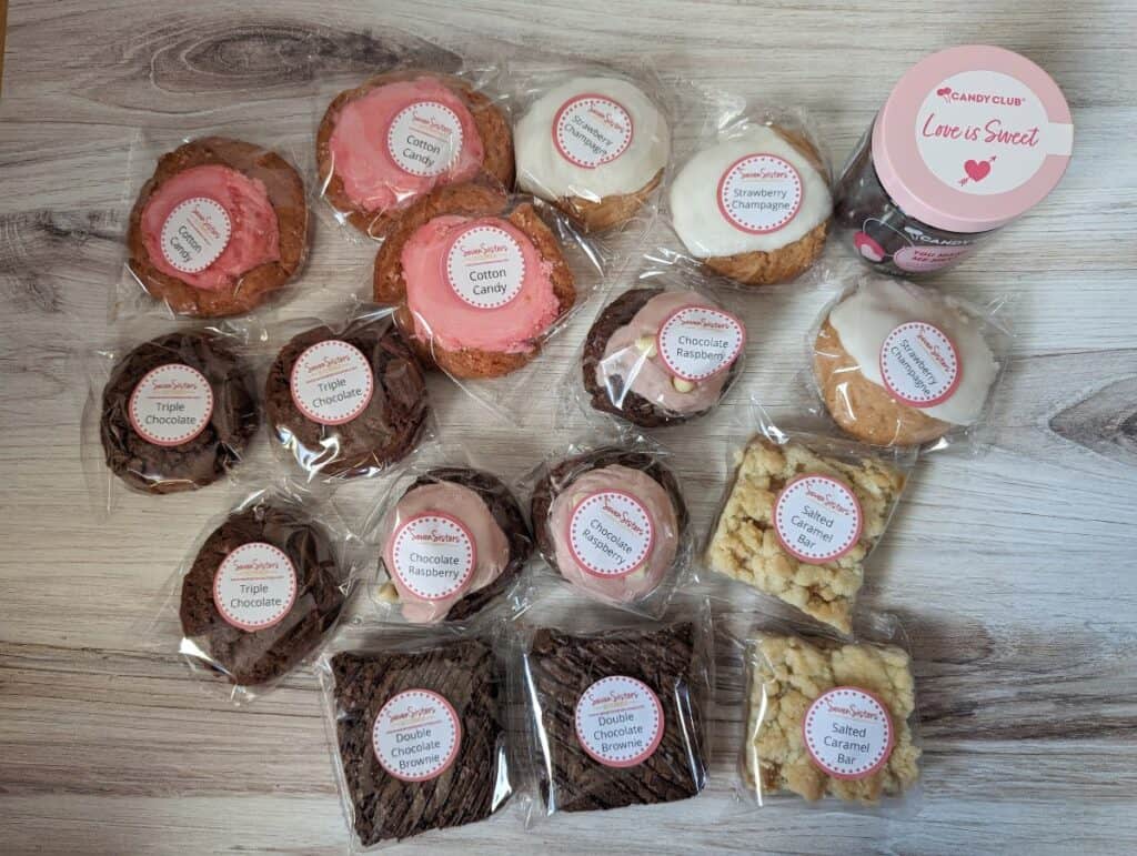 Contents of a scones subscription box laid out on a wooden counter.