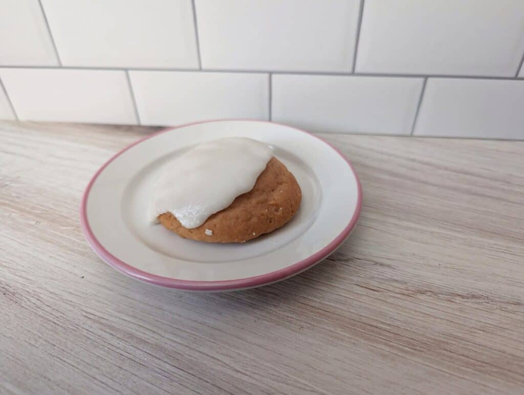 Scone with icing sitting on a plate.