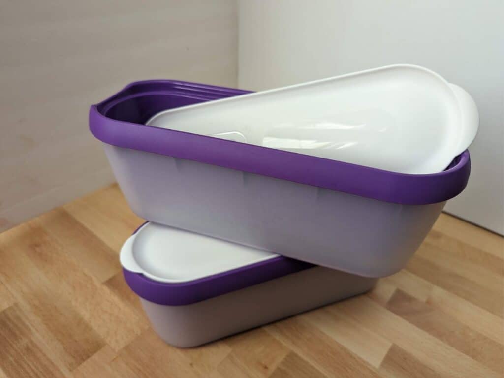 Image shows two ice cream storage containers stacked diagonally on each other.