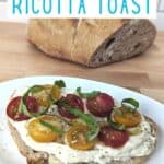 Image shows a Three quarters angle of whipped ricotta toast with tomatoes on a white plate with the bread loaf behind it.