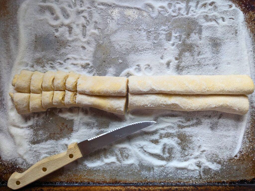 Image shows an Overhead of partially sliced French palmier cookies.