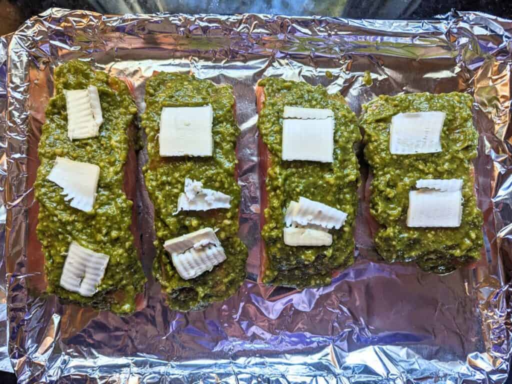 Image shows an Overhead of salmon with pesto and butter.