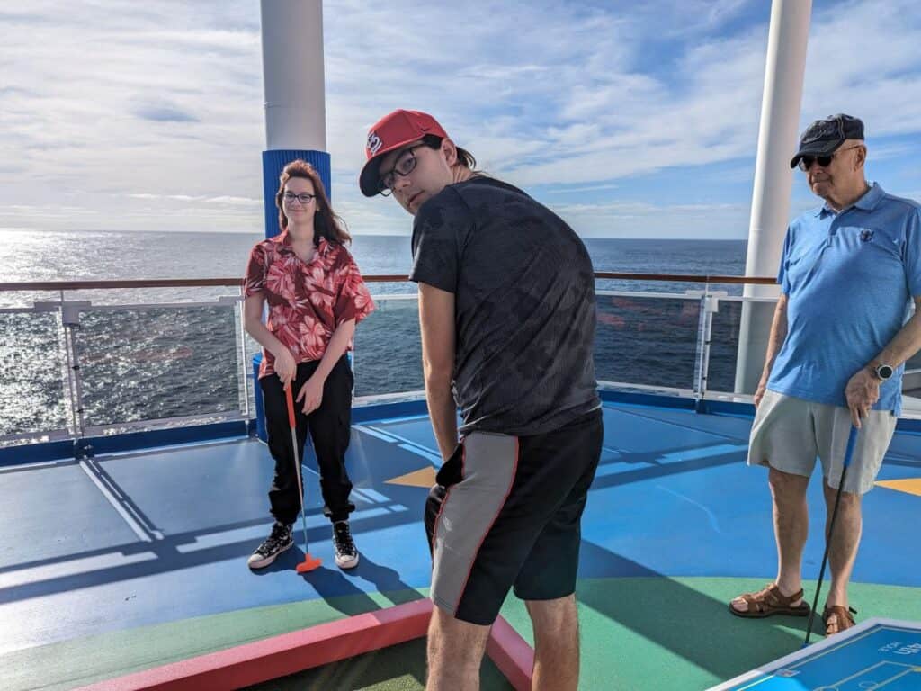 Image shows a family Playing mini golf at sea.