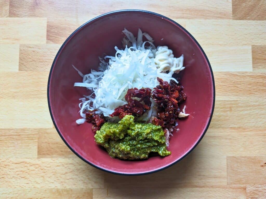 Image shows an overhead view of Pesto tuna salad ingredients.