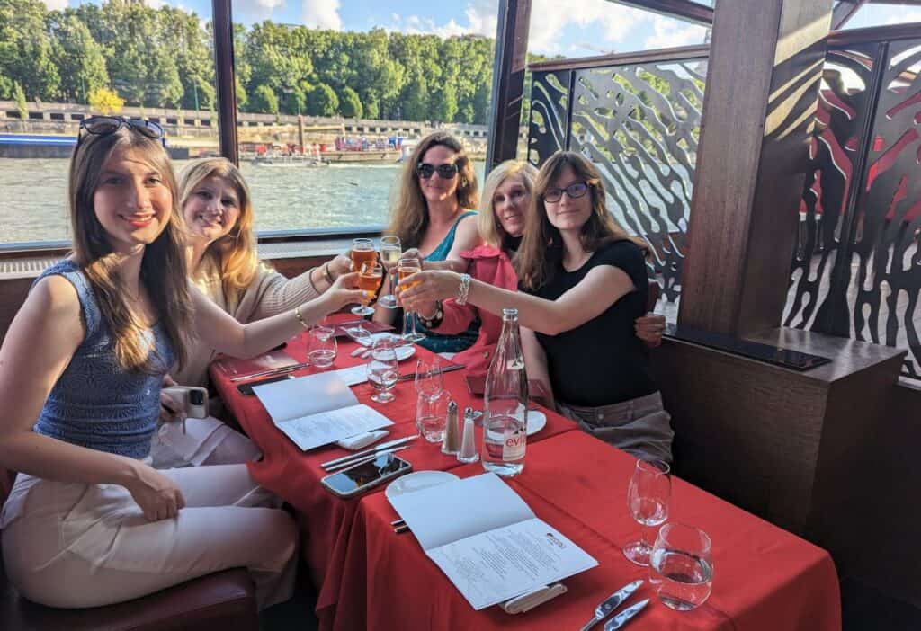 Image shows a Family toasting while at a table on a boat.