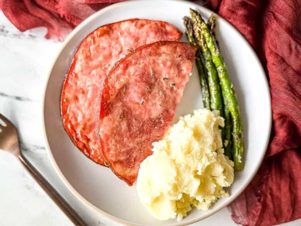 Image shows air fryer ham steak plated and served.