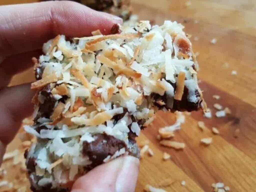 Image shows bite of gluten free seven layer bars.