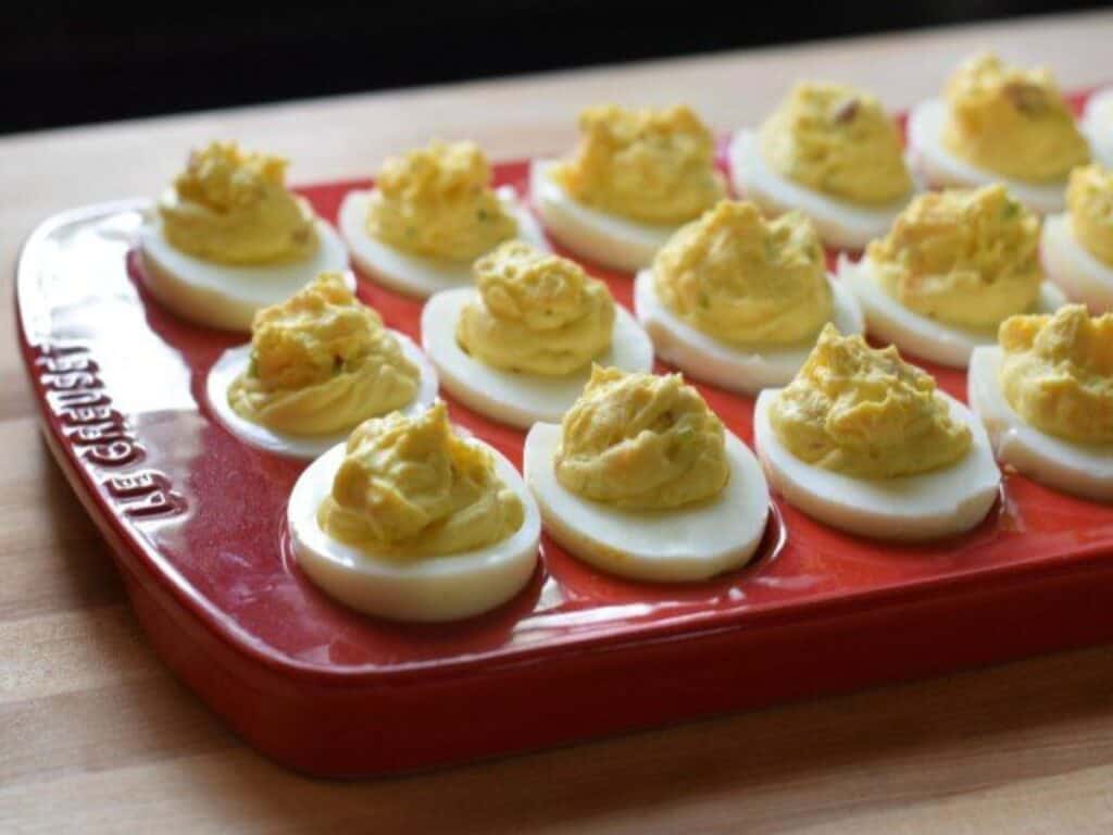 Image shows delicious bacon deviled eggs on a platter.